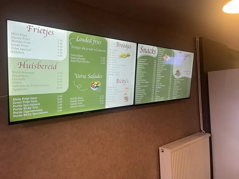 De digitale menuborden van Frituur AanDeKerk aan de muur