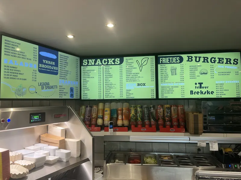 Groene digitale menuborden met snacks, frietjes en burgers bij Frituur Brekske